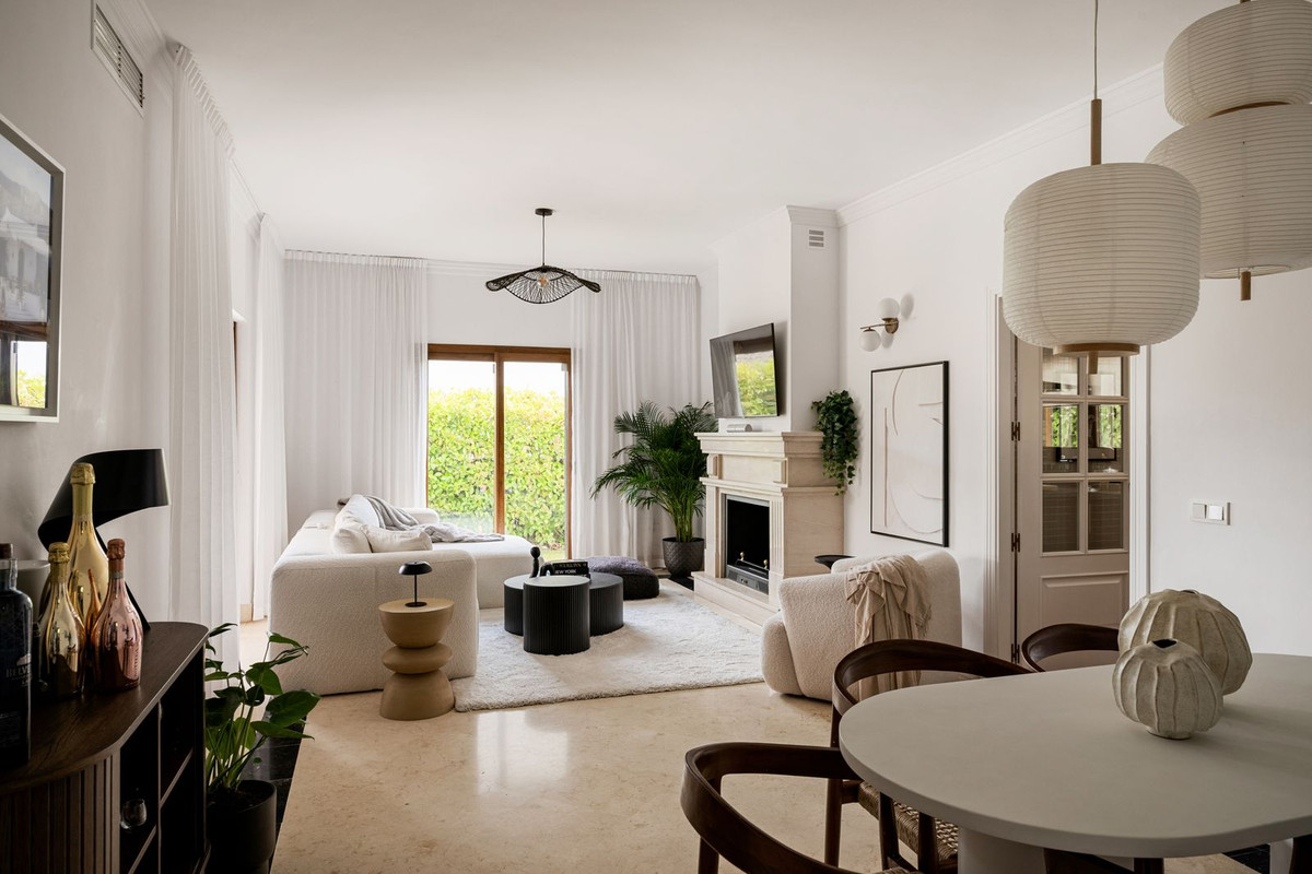Living room with open fireplace, bouclé sofa and limestone floor